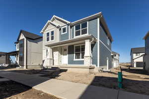 View of front of house with a porch, stone siding, and board and batten siding