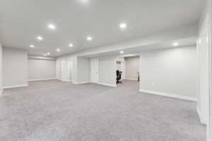 Finished below grade area featuring recessed lighting and light colored carpet