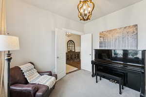 Sitting room featuring a chandelier and carpet floors