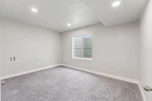 Carpeted empty room featuring baseboards and recessed lighting