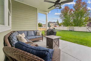 Fenced backyard with ceiling fan, a patio area, an outdoor living space, and a grill
