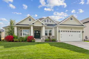 Craftsman-style house featuring a porch, a front lawn, concrete driveway, an attached garage, and a shingled roof