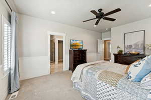 Bedroom with wainscoting, carpet, a decorative wall, ceiling fan, and recessed lighting