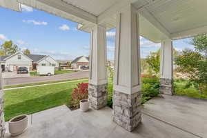 Covered porch featuring a residential view and a lawn
