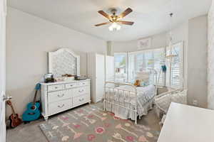 Carpeted bedroom with ceiling fan