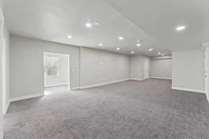 Basement with light carpet and recessed lighting