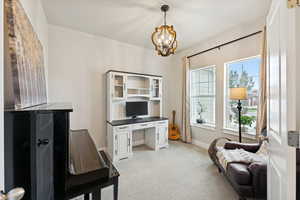 Office area with light carpet and a chandelier