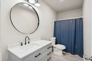 Bathroom with vanity, light wood-style flooring, and curtained shower