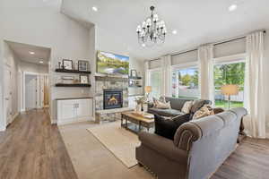 Living area with recessed lighting, light wood-style floors, a fireplace, and high vaulted ceiling