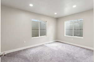 Carpeted spare room with recessed lighting, plenty of natural light, and a textured ceiling