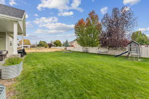 Fenced backyard featuring a playground