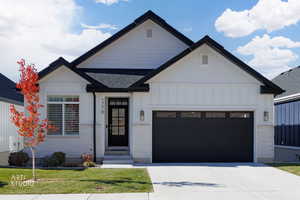 Modern inspired farmhouse with board and batten siding, a garage, concrete driveway, and brick siding