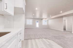 Unfurnished living room featuring recessed lighting, light wood finished floors, and light carpet