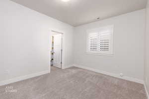 Empty room with carpet floors and a textured ceiling