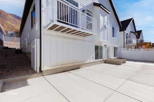 Back of property with board and batten siding, a balcony, and a residential view