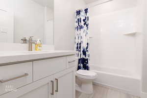 Bathroom featuring vanity, shower / tub combo with curtain, and light wood finished floors