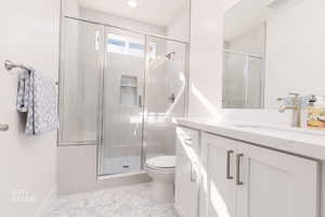 Bathroom with vanity, a shower stall, and light tile patterned floors