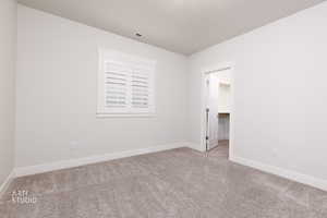 Spare room featuring carpet and a textured ceiling