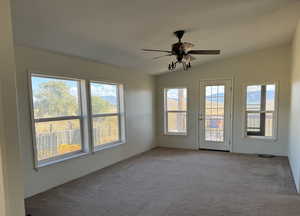 Spare room with carpet, a ceiling fan, and vaulted ceiling