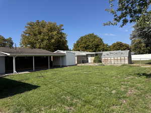 View of yard featuring a patio, an outbuilding, and a greenhouse