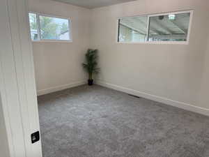 Empty room featuring carpet floors and baseboards