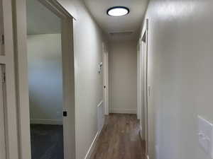 Hallway with wood finished floors and a textured ceiling