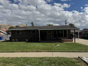 Ranch-style home featuring covered porch, brick siding, and a shingled roof