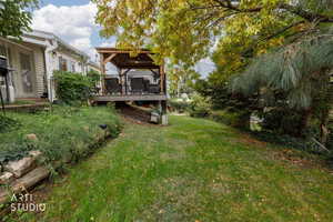 View of grassy yard with a deck