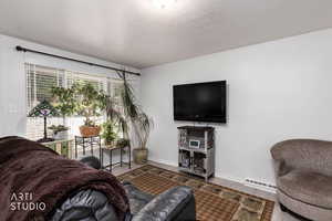 Living area featuring wood finished floors and baseboard heating