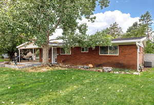 View of front of property with a front lawn, brick siding, and a patio