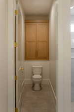 Bathroom with toilet and light tile patterned floors