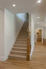 Staircase featuring recessed lighting and wood finished floors