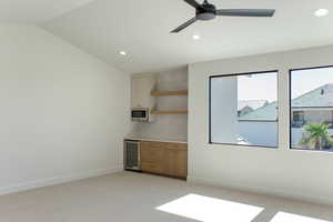 Spare room with recessed lighting, light carpet, wine cooler, ceiling fan, and lofted ceiling
