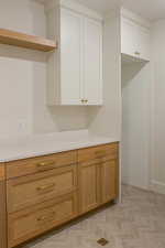 Kitchen featuring light countertops, white cabinets, and open shelves