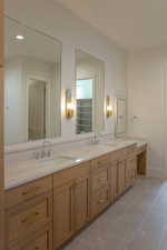 Bathroom with double vanity, light tile patterned flooring, and recessed lighting