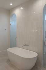 Full bathroom featuring tile walls, a freestanding tub, a shower stall, tile patterned floors, and recessed lighting