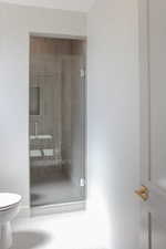 Bathroom with a shower stall and tile patterned floors