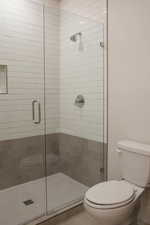 Bathroom featuring toilet and a shower stall