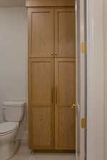 Half bathroom featuring light tile patterned floors and a closet