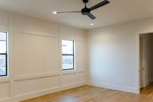 Spare room featuring light wood-style floors, recessed lighting, a decorative wall, and a ceiling fan