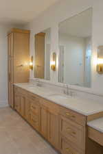Full bathroom with double vanity and light tile patterned floors
