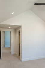 Hall with light carpet, recessed lighting, and lofted ceiling