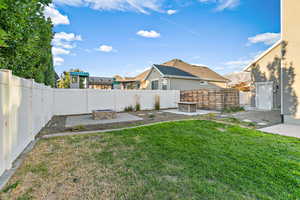 Fenced backyard with a patio area and a fire pit