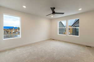 Empty room with light colored carpet and recessed lighting