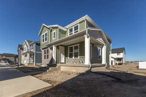View of front of house featuring board and batten siding, a porch, and a residential view