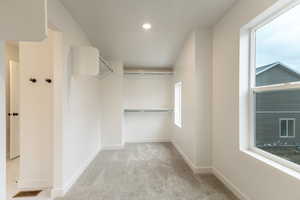 Walk in closet featuring light carpet