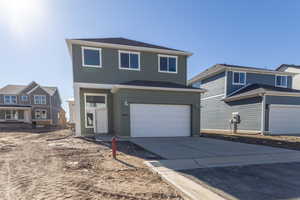 View of front of property featuring concrete driveway, an attached garage, and roof with shingles