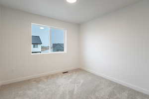 Carpeted empty room featuring baseboards