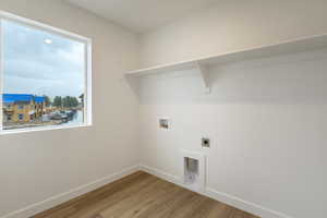 Laundry area featuring light wood finished floors, washer hookup, and hookup for an electric dryer