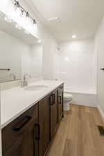 Bathroom featuring light wood-style floors, vanity, tub / shower combination, and recessed lighting
